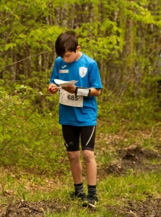 Ragazzo che legge la carta nel bosco